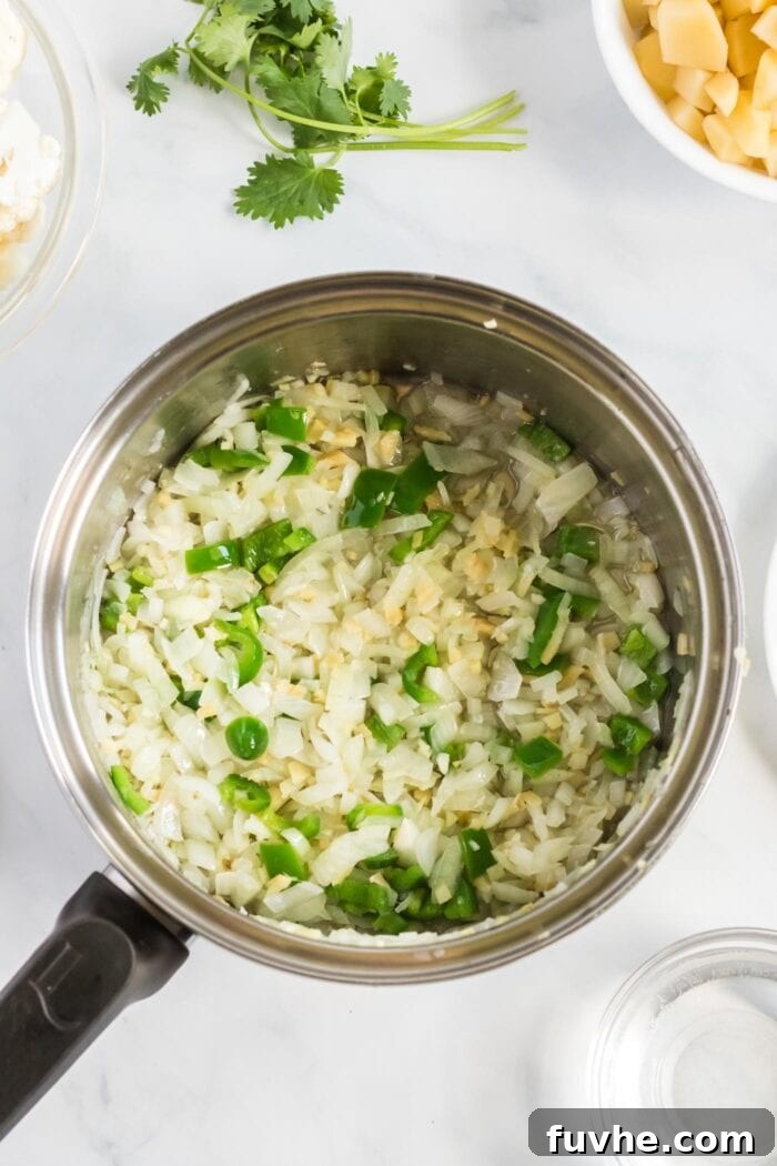 Comforting Cauliflower Potato Curry 4 Diced onions, minced garlic, grated ginger, and sliced jalapeño are gently sizzling in coconut oil in a large pot, filling the kitchen with fragrant aromas.