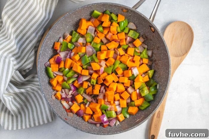 Hearty Sweet Potato Quinoa Skillet 5 Diced sweet potato, bell pepper and onion cooking in a skillet.