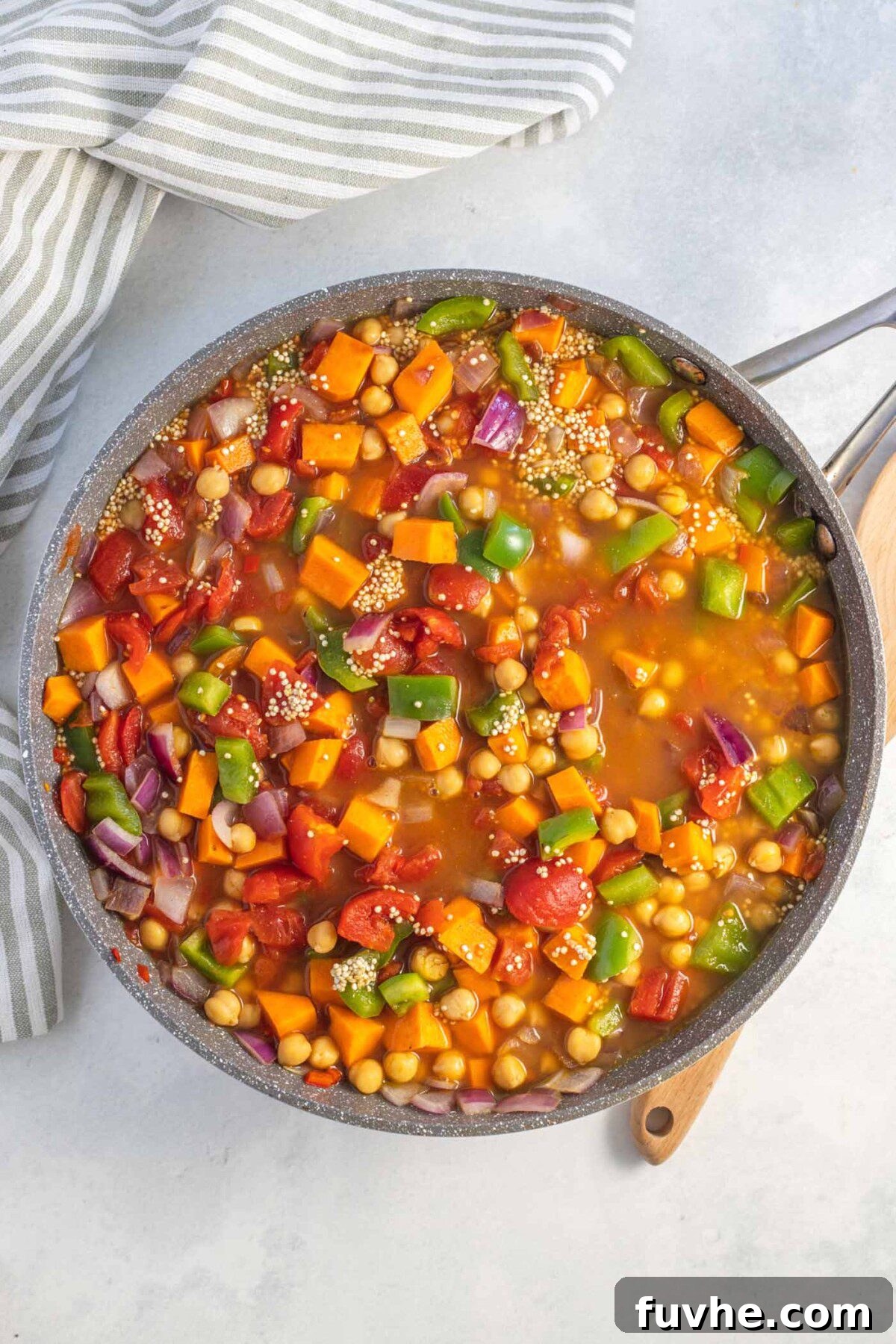 Hearty Sweet Potato Quinoa Skillet 6 Chickpeas and quinoa cooking in a tomato broth in a large skillet.