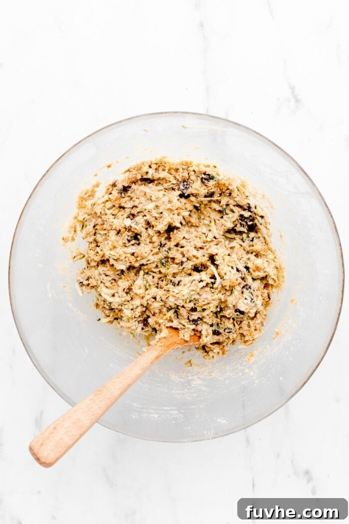 Raw chocolate chip zucchini cookie batter in a glass mixing bowl.