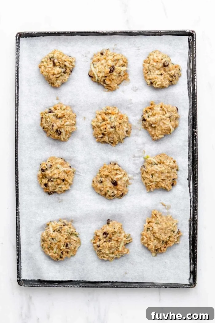 Raw chocolate chip zucchini cookies on a baking tray.