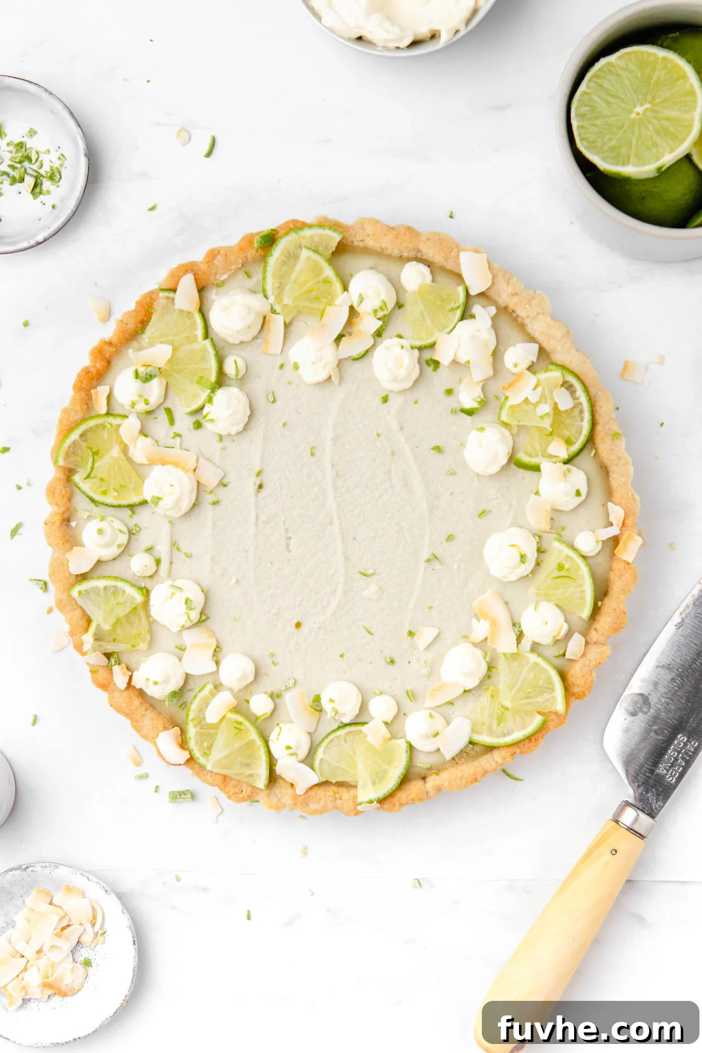 Plant-Based Key Lime Paradise 2 Overhead view of a beautifully prepared vegan key lime pie, generously topped with fluffy dairy-free whipped cream and delicate slices of fresh lime, ready to be served.