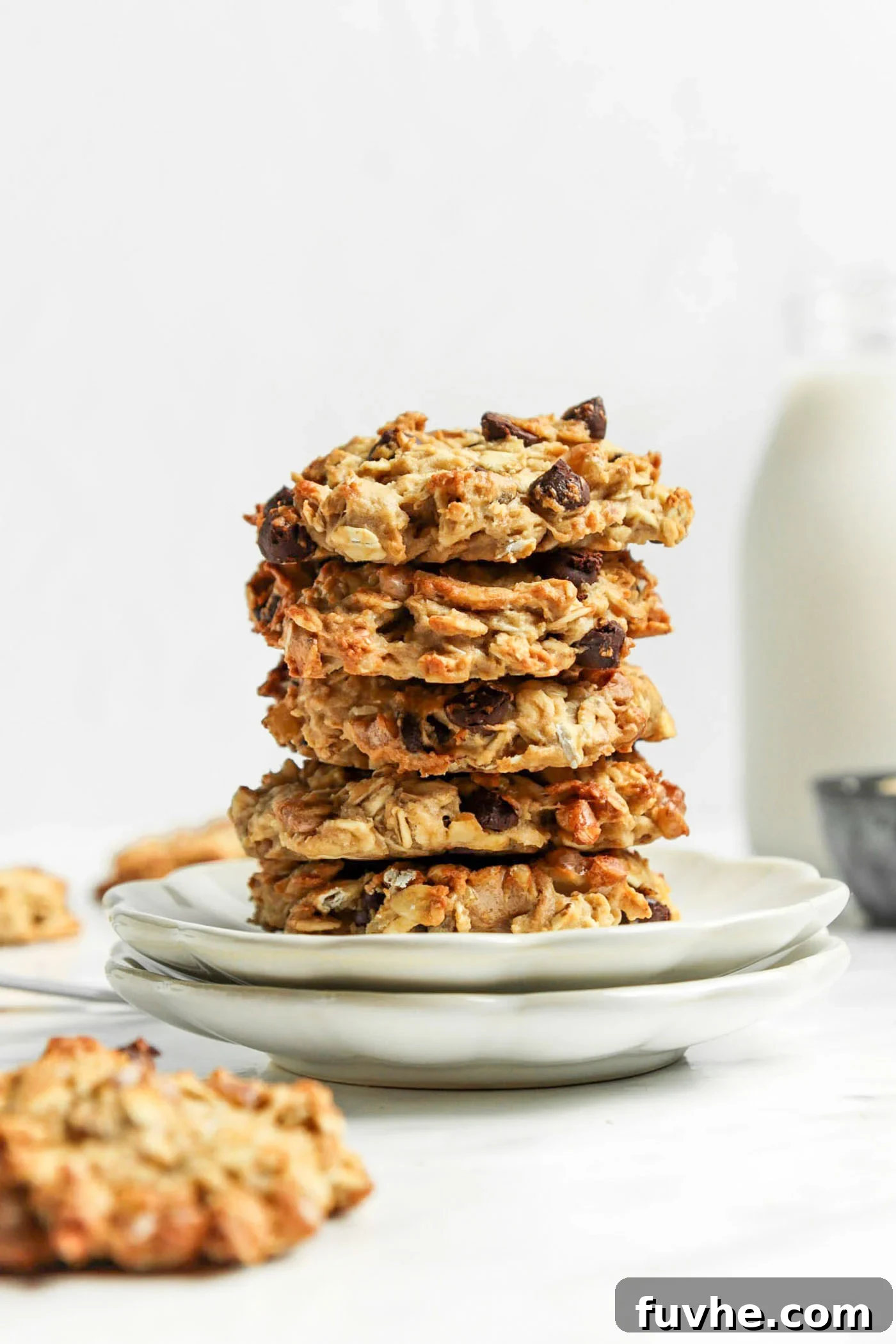 Stack of 3 oatmeal chocolate chip cookies on a small white plate, ready to be enjoyed as a healthy vegan breakfast or snack.