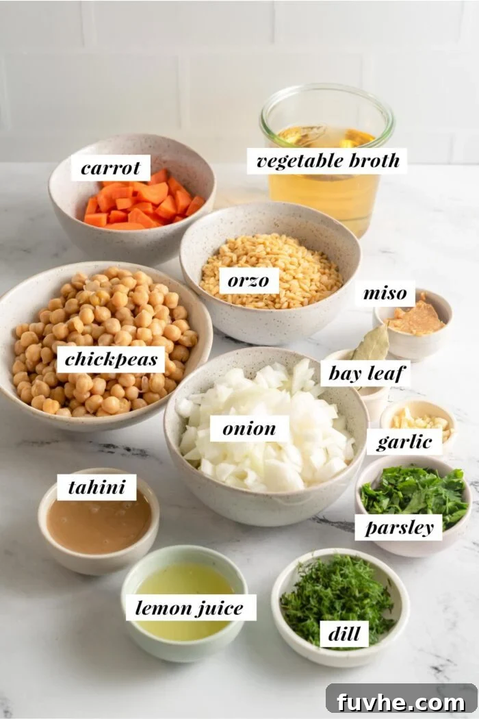 Visual list of ingredients for making a lemon orzo soup with chickpeas, spinach, onion and carrot.