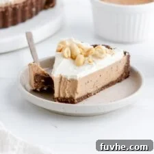 Slice of vegan peanut butter pie on a plate with a bite taken, showcasing its delicious layers and creamy filling.