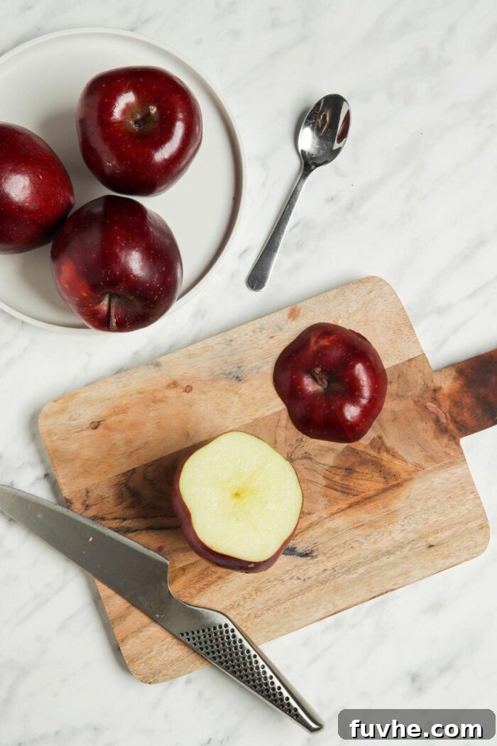 Wholesome Vegan Stuffed Apples 4 An apple on a cutting board with its top neatly sliced off, ready for coring.