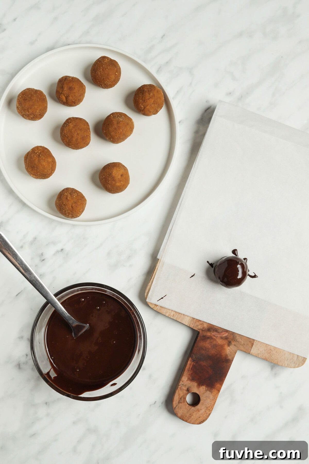 Spiced Vegan Pumpkin Chocolate Truffles 5 Pumpkin balls being rolled in chocolate.