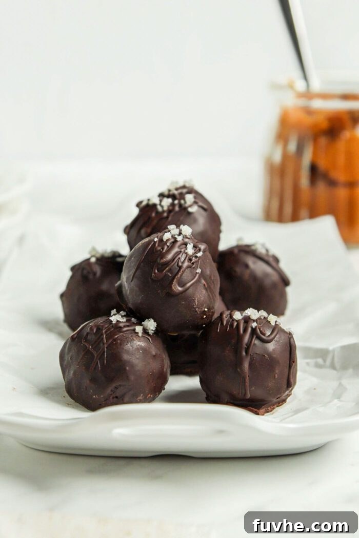 Spiced Vegan Pumpkin Chocolate Truffles 7 Chocolate truffles on a parchment paper-lined tray.