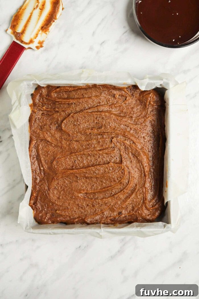 Date caramel spread into an even layer in a square baking pan.