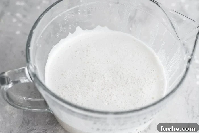 Strained homemade almond milk in a large glass measuring cup.