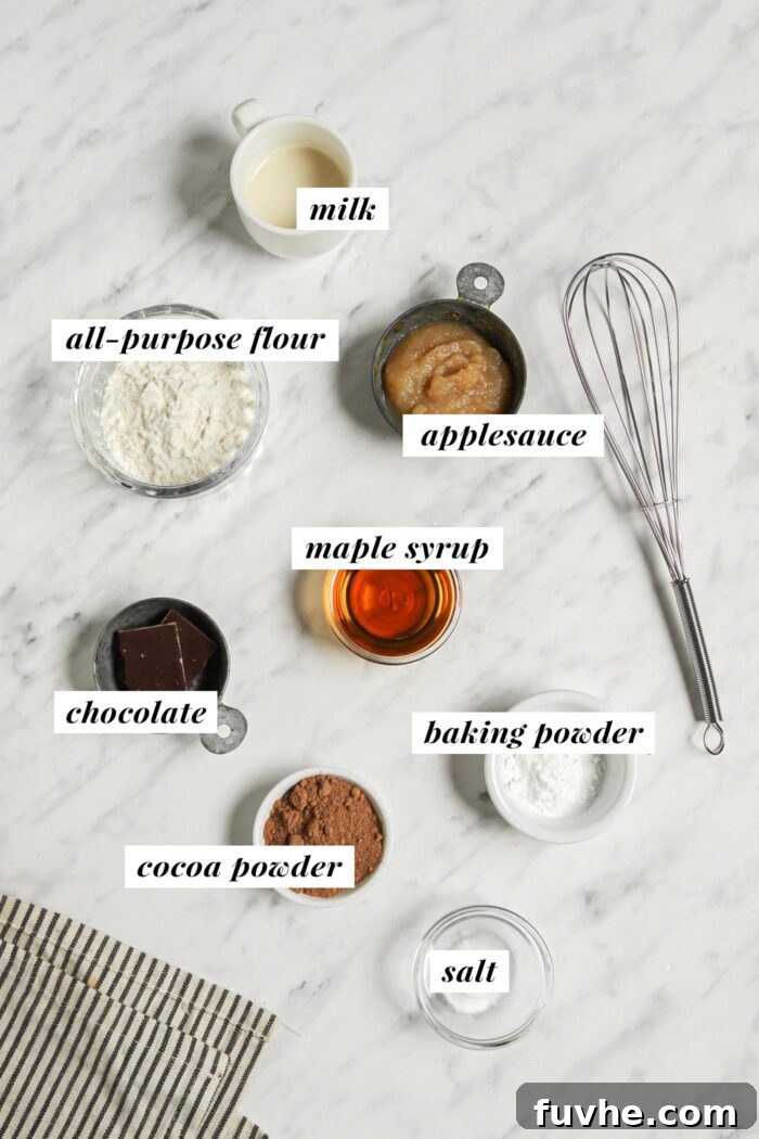 Mugful of Vegan Chocolate Bliss 3 A visual display of all the necessary ingredients laid out for preparing a delicious chocolate mug cake recipe, each clearly labeled for easy identification.