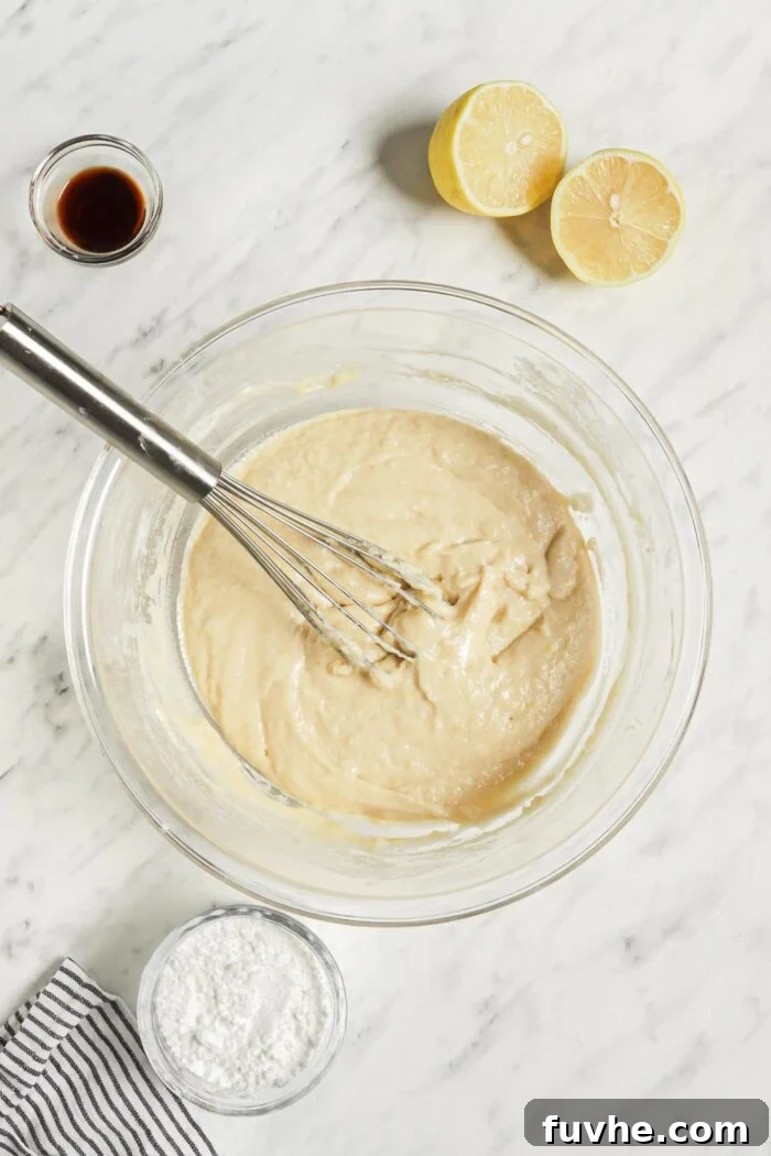 Zesty Vegan Lemon Loaf 5 Thick and smooth lemon loaf cake batter in a mixing bowl with a metal whisk.