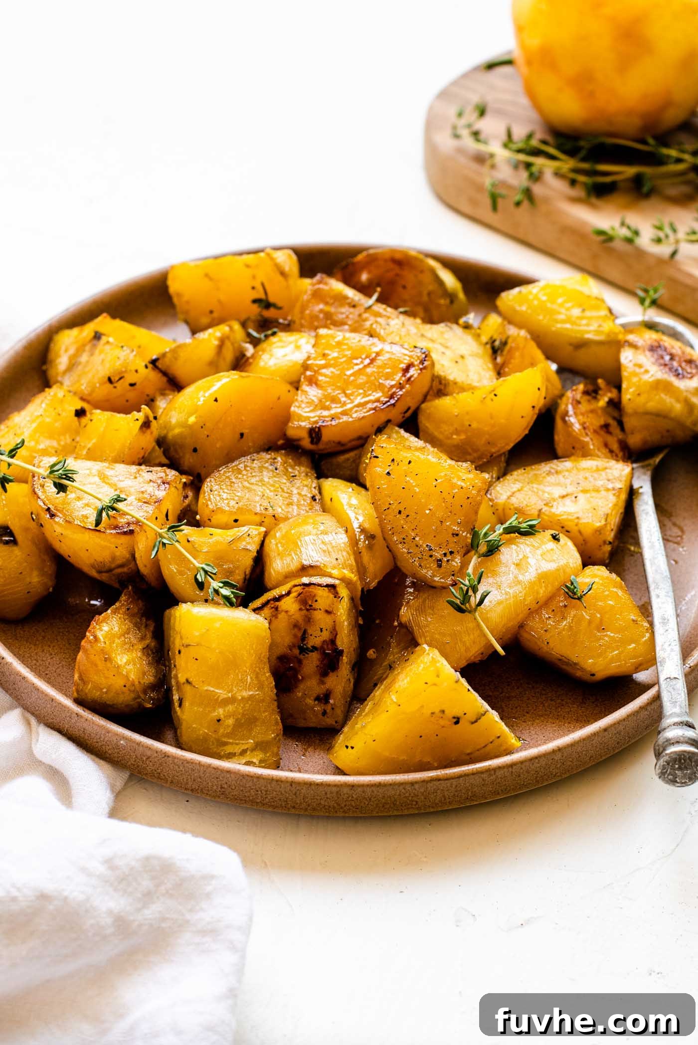 Plate of roasted golden beets with fresh thyme, ready to serve.