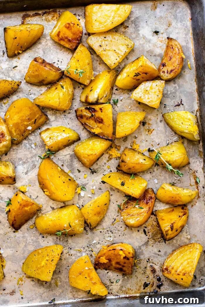 Roasted golden beets with sprigs of fresh thyme on a baking pan, just out of the oven.