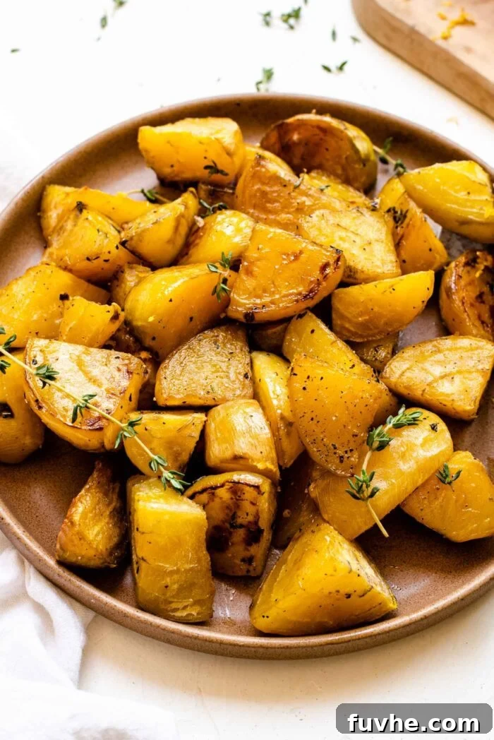 Close-up of a plate of roasted golden beets with fresh thyme, emphasizing texture and golden hue.