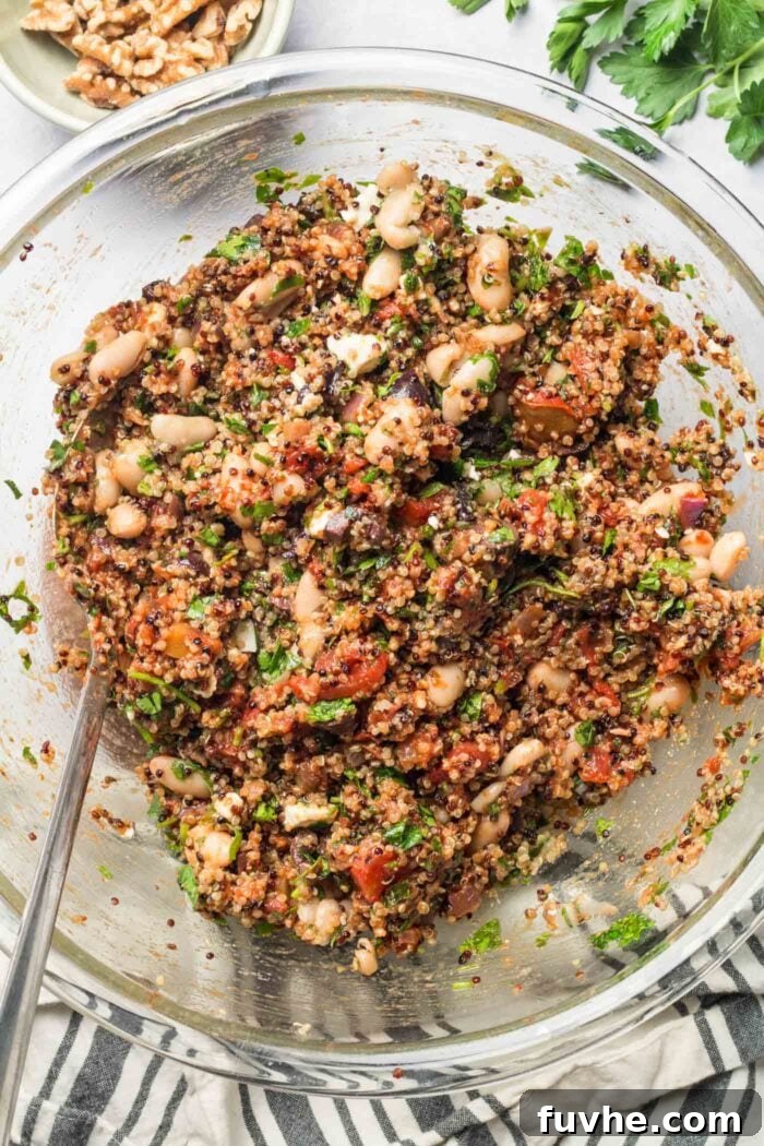 Mediterranean quinoa filling with white beans and various vegetables, perfectly mixed and ready to be spooned into bell peppers.