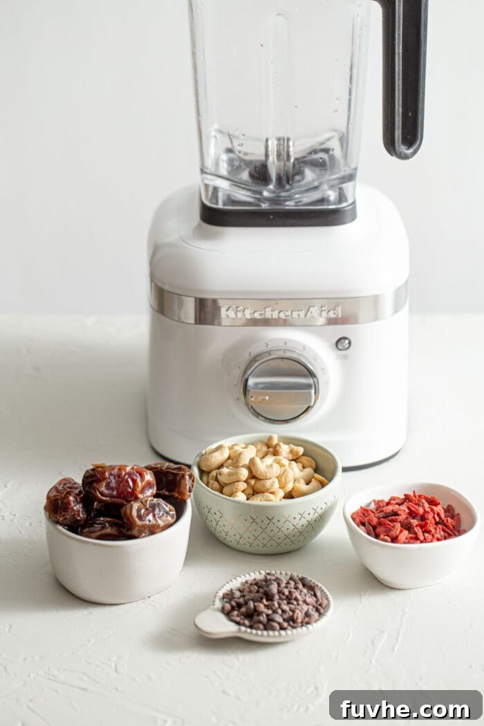 4 small bowls of dates, cashews, cacao nibs and goji berries.