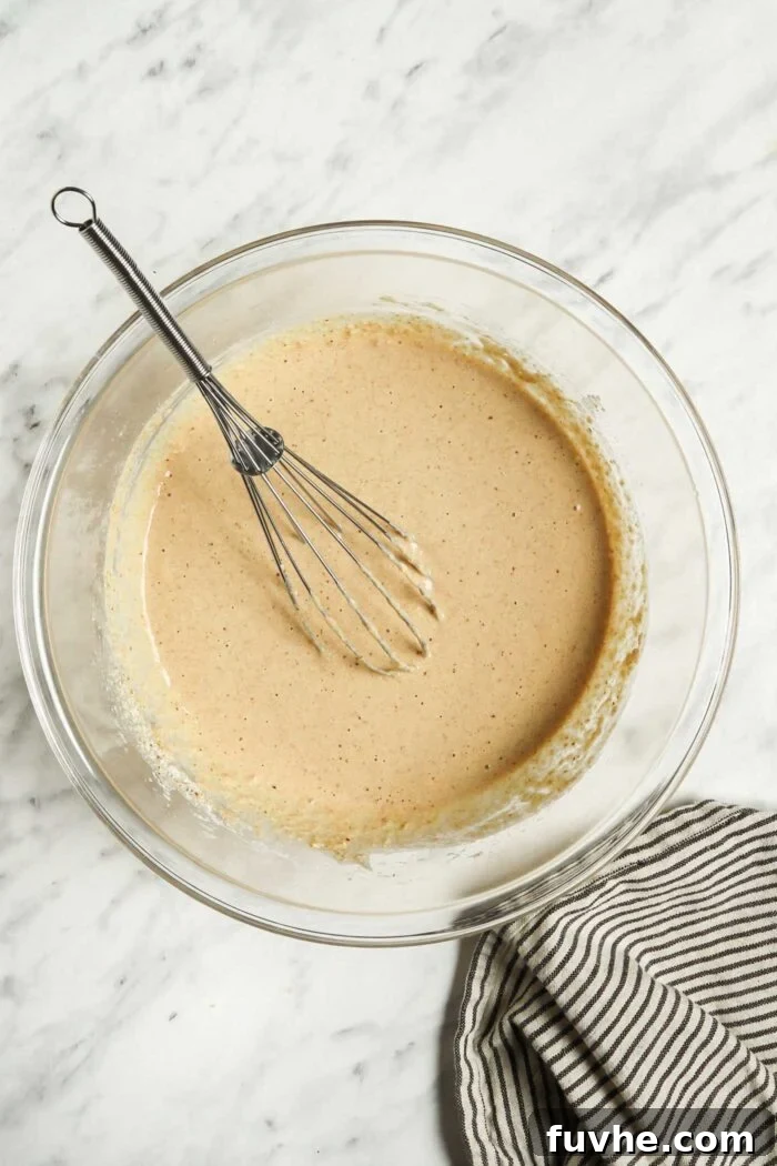 Banana oat pancake batter in a glass mixing bowl.