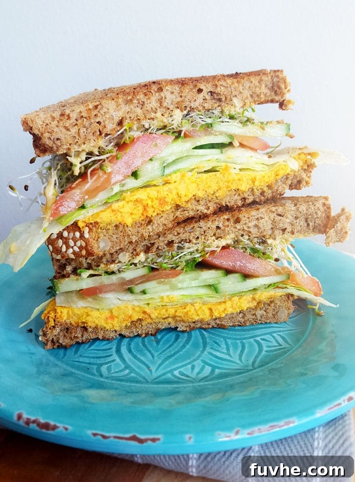 Fuel Your Journey: 14 Vegan Road Trip Snacks 4 Two halves of a vegetable and hummus sandwich stacked on top of each other.
