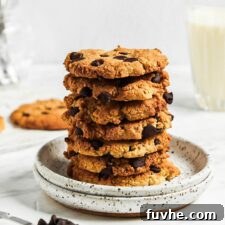 Stack of almond flour chocolate chip cookies on a small plate with a glass of milk in the background.