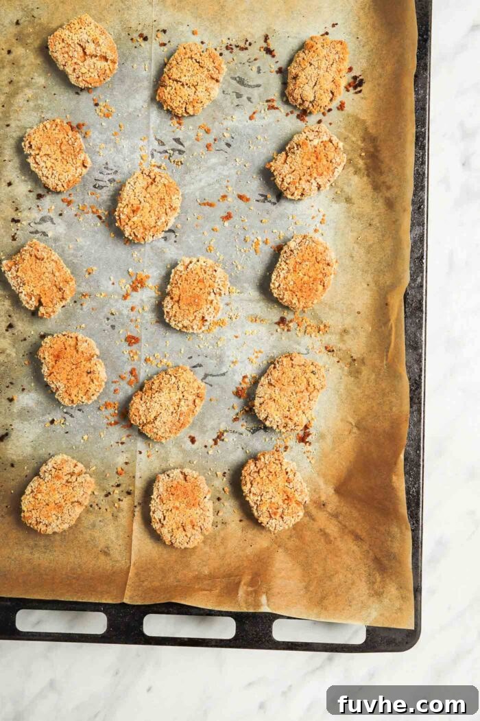 Crispy Baked Tofu Bites 7 A baking sheet filled with an even layer of golden-brown, crispy baked tofu nuggets, fresh out of the oven and perfectly cooked.