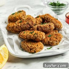 Plate of baked tofu nuggets with a small bowl of ketchup in the background.