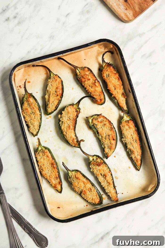 Creamy Vegan Jalapeño Bites 8 A baking tray filled with perfectly golden and crispy baked vegan jalapeño poppers, fresh out of the oven and steaming.