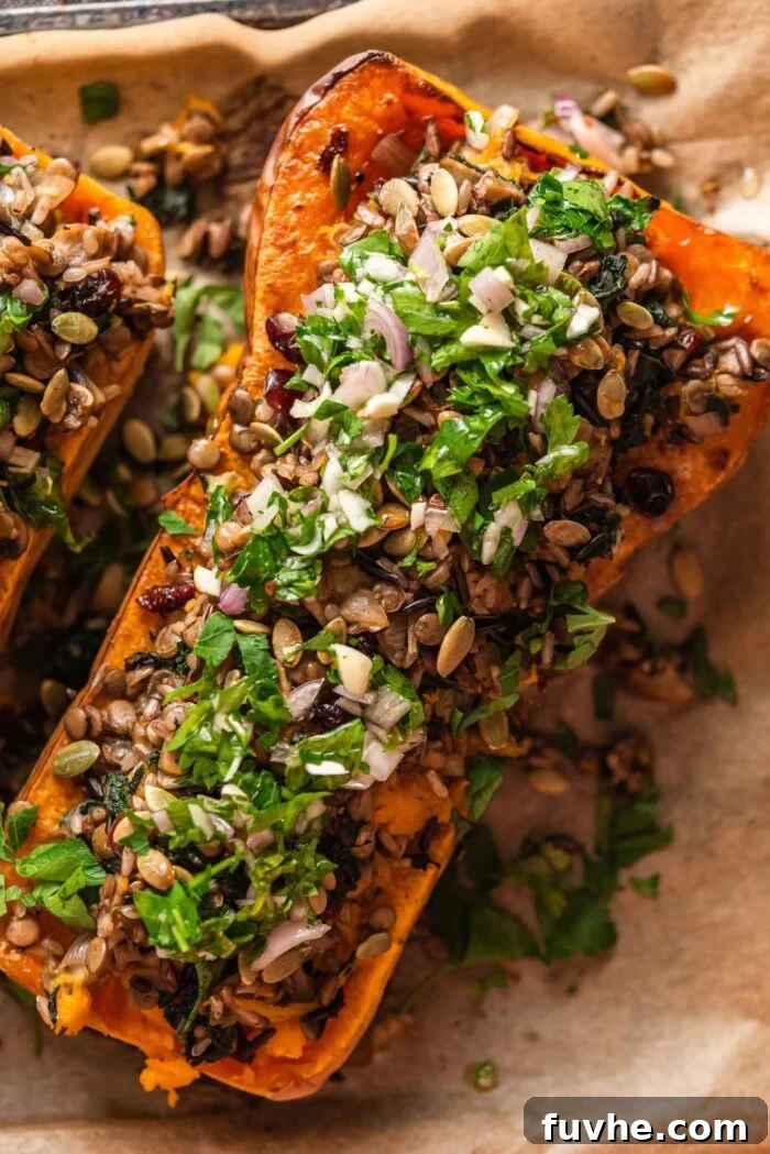 Comforting Vegan Stuffed Butternut Squash 11 A perfectly cooked stuffed butternut squash, generously filled with a flavorful rice and lentil mixture and elegantly topped with fresh parsley salsa verde, ready to be served.
