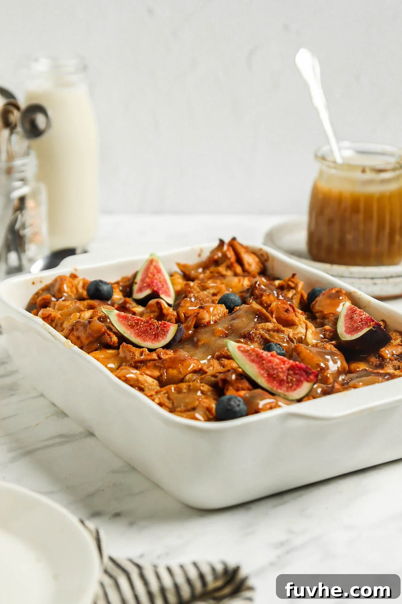 Baked french toast casserole topped with sliced figs and caramel sauce.