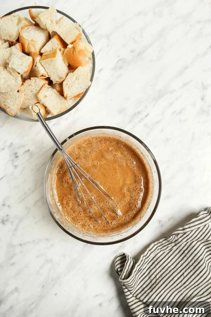 Applesauce and coconut sugar mixed together in a glass mixing bowl with a metal whisk.
