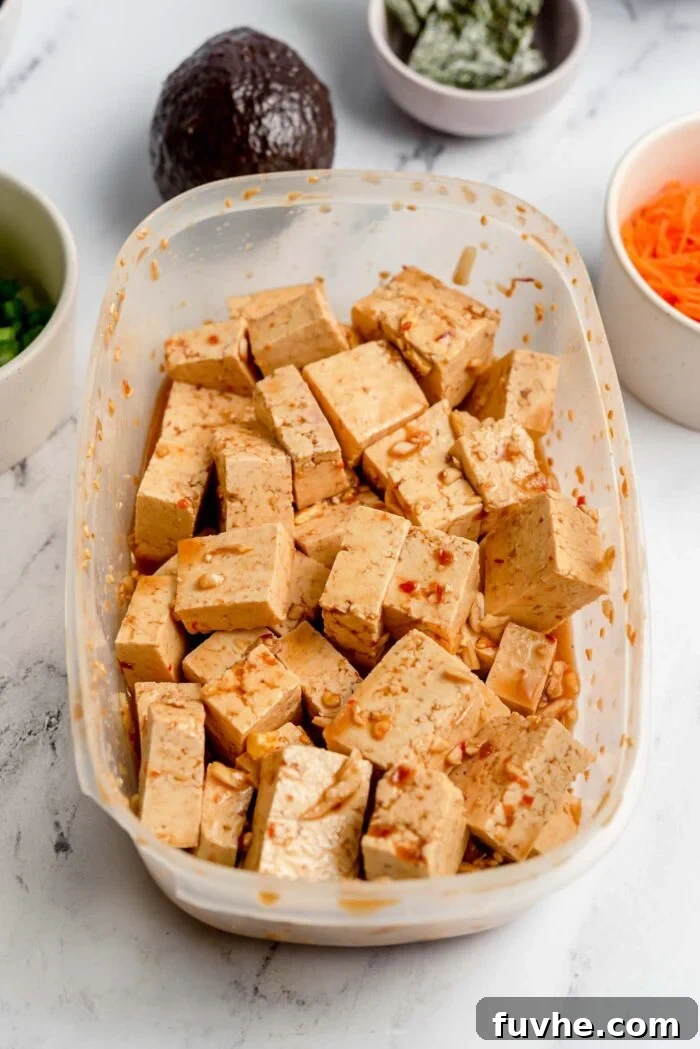 Cubed tofu marinated in a ginger soy sauce in a Tupperwear container.