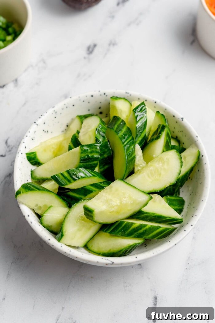 Sliced cucumber in a small ceramic bowl.