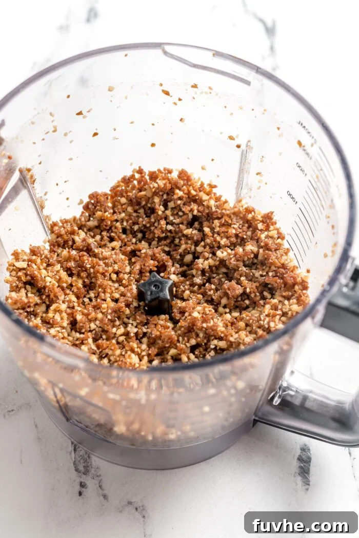 Quick and Easy No-Bake Pecan Tartlets 4 Blended dates and walnuts in a food processor container.
