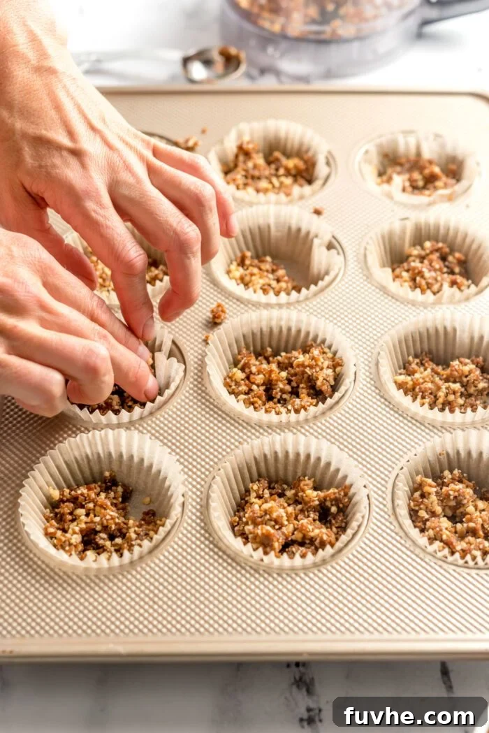 Quick and Easy No-Bake Pecan Tartlets 5 Pressing dough down into a cupcake liner-lined 12 piece muffin tin.