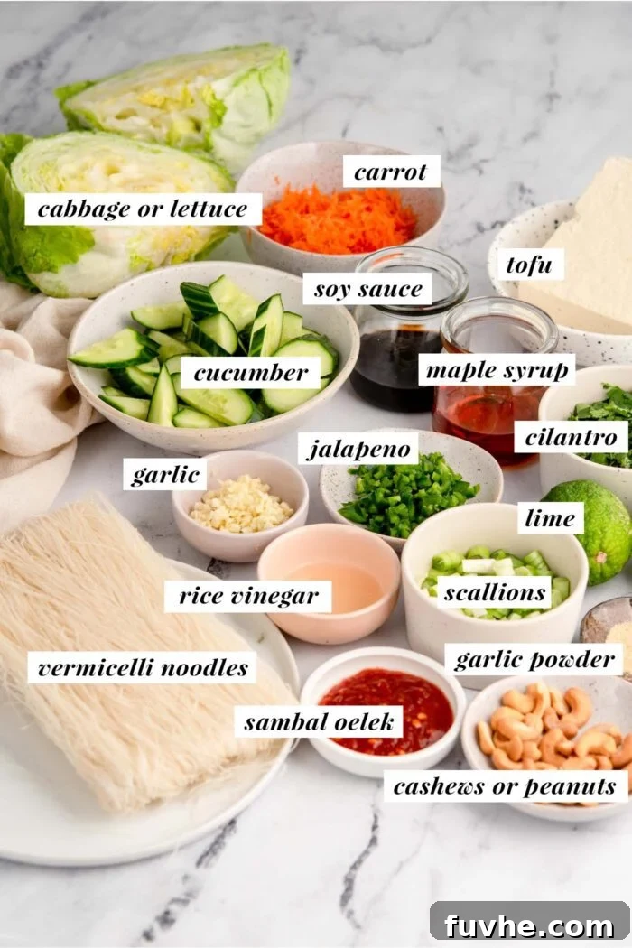 All the fresh ingredients, including extra-firm tofu, various vegetables, and components for a sweet and spicy sauce, are laid out on a wooden surface, ready for preparing the rice vermicelli noodle salad.