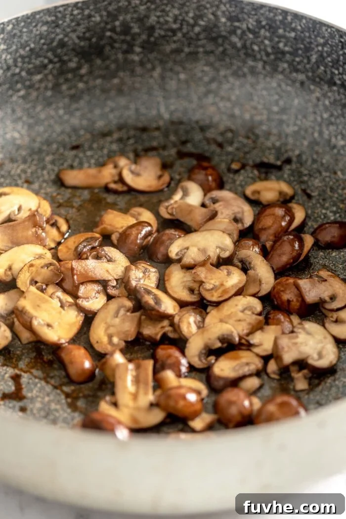 Plant-Based Carbonara 6 Chopped mushrooms cooking in a saucepan.
