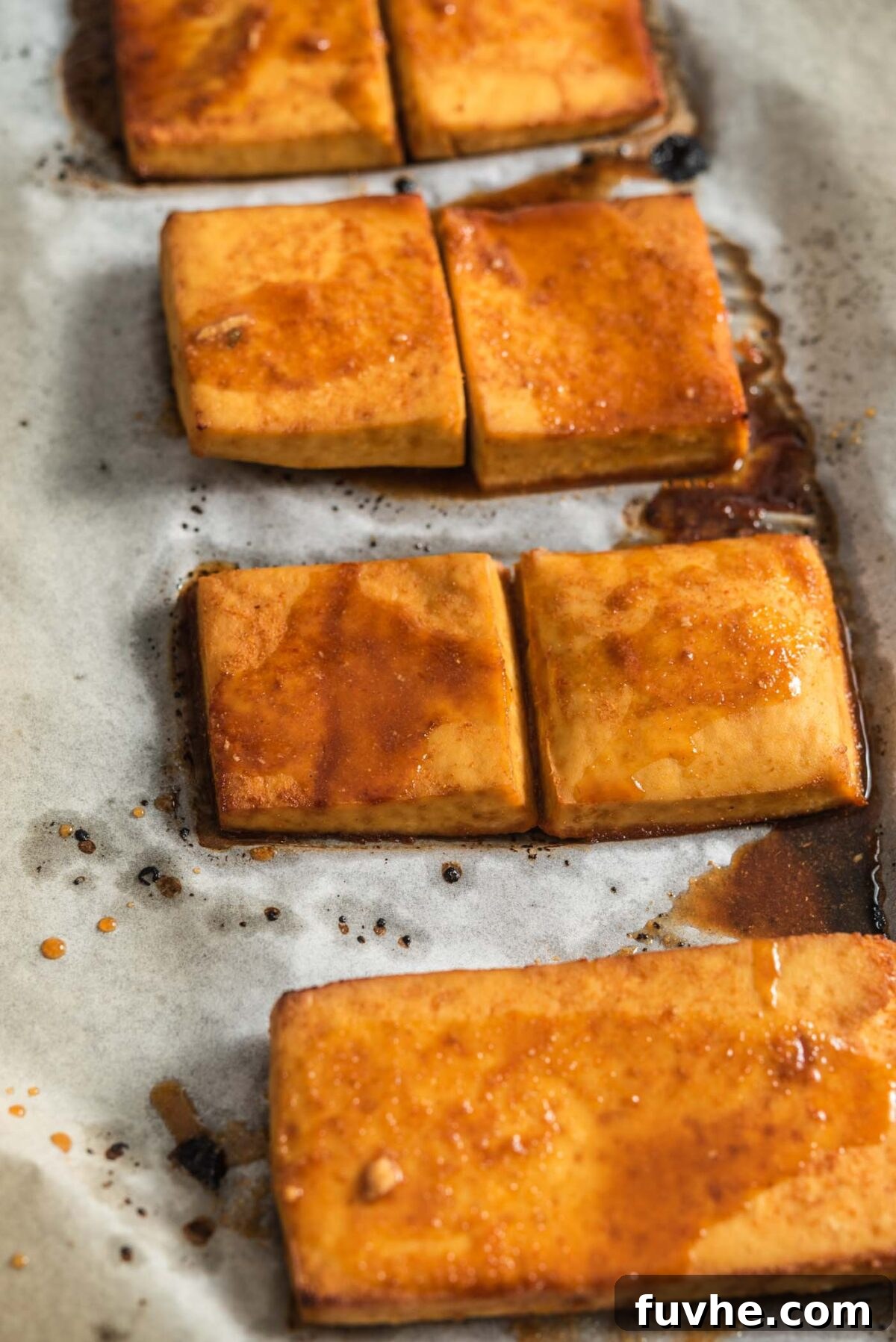 Ultimate Vegan Tofu Banh Mi 6 Thick slices of baked tofu coated in marinade on a baking tray.