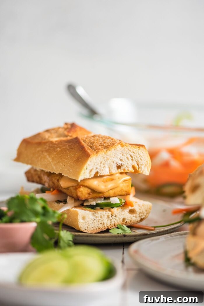 Ultimate Vegan Tofu Banh Mi 8 Tofu bahn mi sandwich with spicy mayo and pickled veggies on a plate.