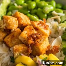 Colourful tofu bowl with mango salsa, edamame, avocado, cucumber, radish and sweet chili tofu.