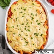 Hearty Plant-Based Baked Ziti 13 Overhead view of baked ziti sprinkled with fresh herbs in an oval baking dish.