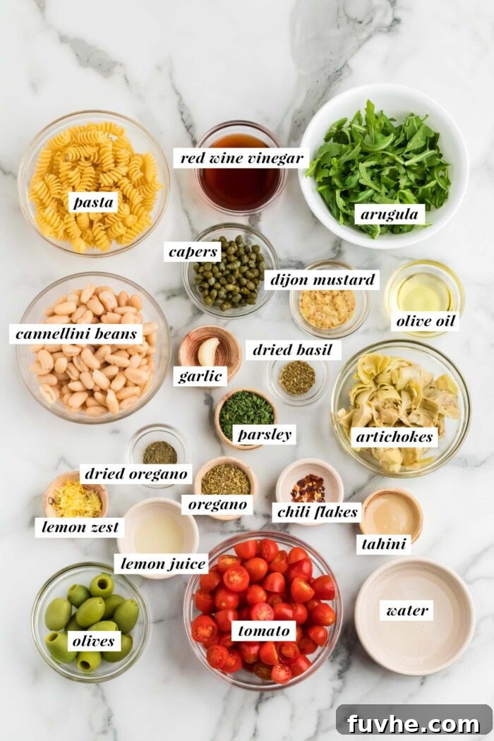 An overhead shot showcasing all the fresh and vibrant ingredients neatly arranged for making a vegan zesty Italian pasta salad. Each ingredient is clearly visible and ready for preparation, highlighting the simplicity and wholesome nature of the recipe.