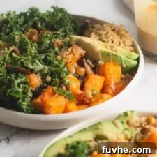 Vibrant Vegan Quinoa Fuel Bowls 10 Two quinoa power bowls with butternut squash, chickpeas, kale and avocado. A jar of maple dijon dressing is in the background.