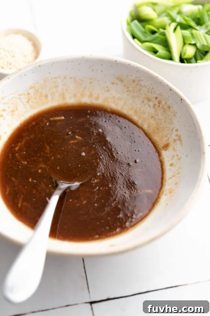 Zesty Soba Noodle Delight 4 Sesame miso garlic sauce mixed together in a small bowl. A spoon rests in the bowl.