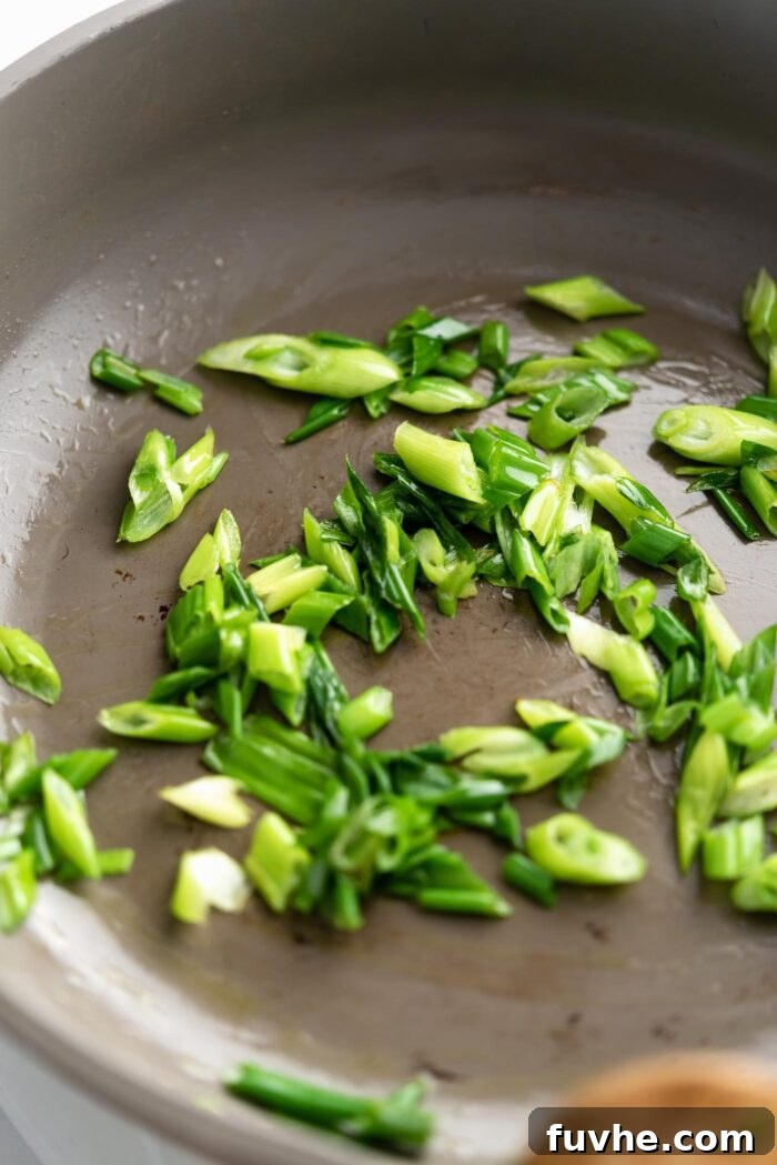 Zesty Soba Noodle Delight 5 Thinly sliced stir fried green onions cooking in a pan.