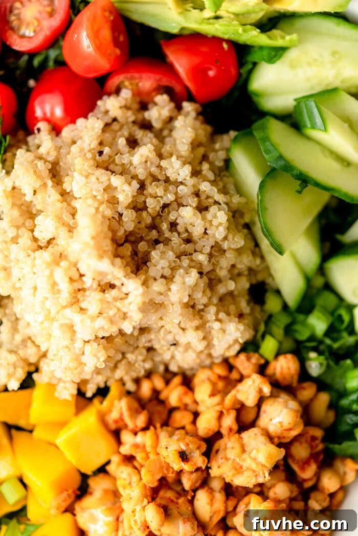 Close up of quinoa, tempeh, mango, cucumber, tomato and avocado.