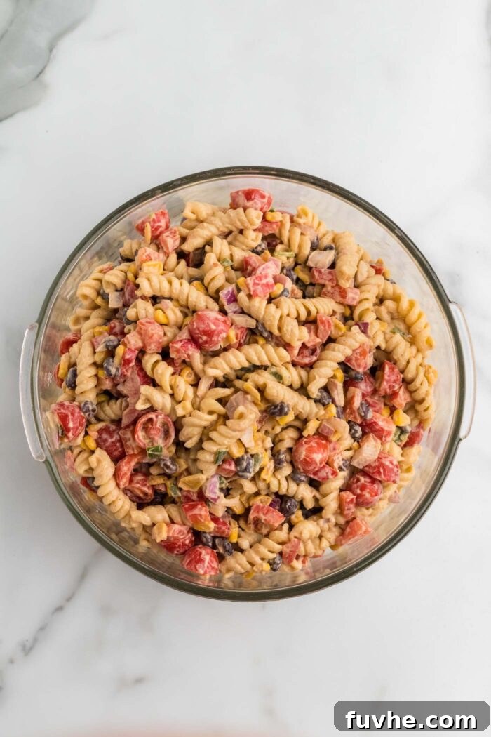 Chipotle Lime Vegan Pasta Salad 8 Overhead view into a bowl of Southwest pasta salad with black beans, tomato, corn, jalapeno and creamy cashew chipotle dressing.
