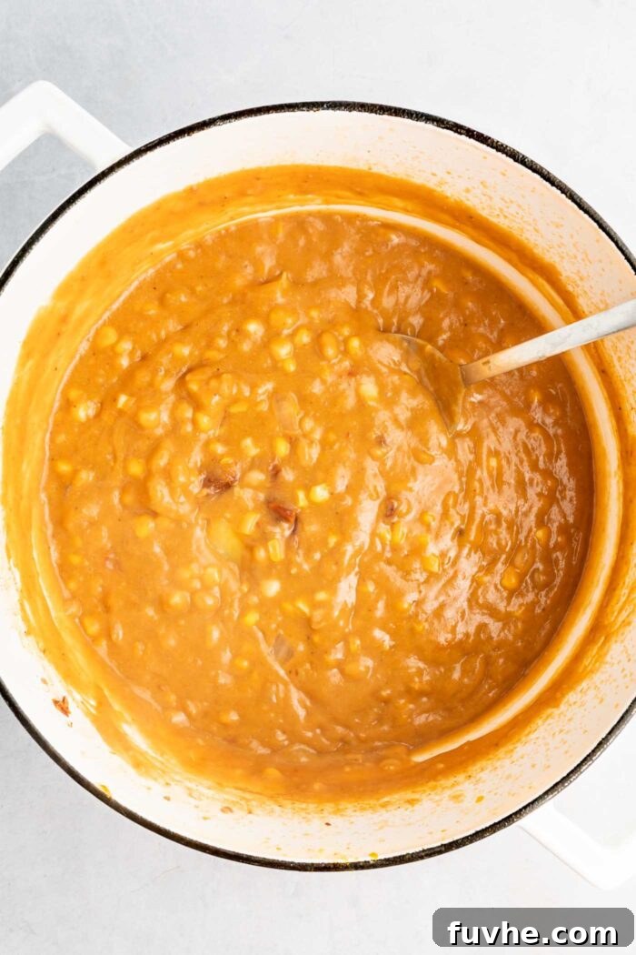 Sunny Vegan Corn Chowder 7 A large pot of rich, creamy summer corn and potato chowder, vibrant with whole corn kernels, after the blended portion has been incorporated and stirred, ready for final seasoning.