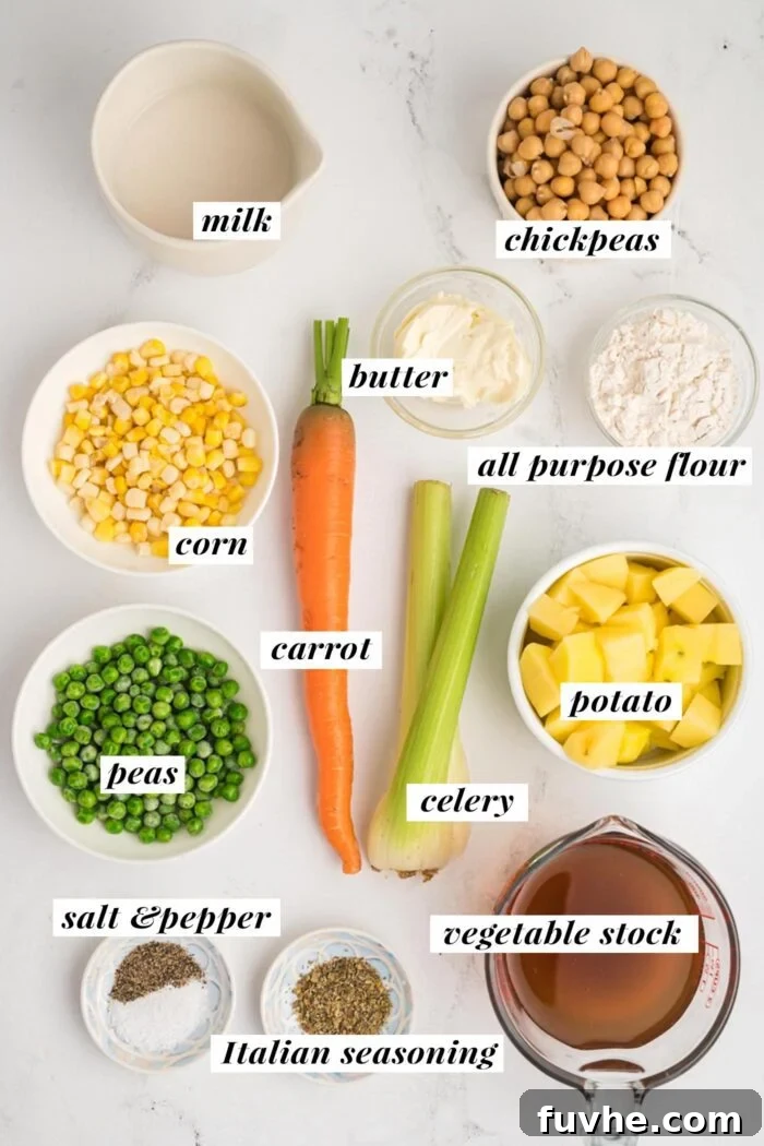 A collection of fresh and packaged ingredients laid out on a kitchen counter, including plant-based butter, vegetable stock, almond milk, frozen peas and corn, chickpeas, Yukon Gold potatoes, carrots, celery, and Italian seasoning—all prepped for making a vegetarian pot pie.