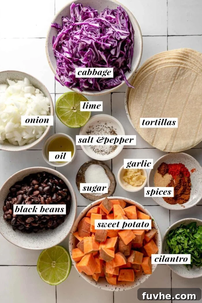 Spiced Sweet Potato and Black Bean Tacos 3 A vibrant display of fresh ingredients for sweet potato and black bean tacos. Bowls hold cubed sweet potato, black beans, red onion, garlic, cilantro, and an assortment of spices like smoked paprika, cumin, and chili powder. A wedge of lime and shredded cabbage complete the colorful setup.