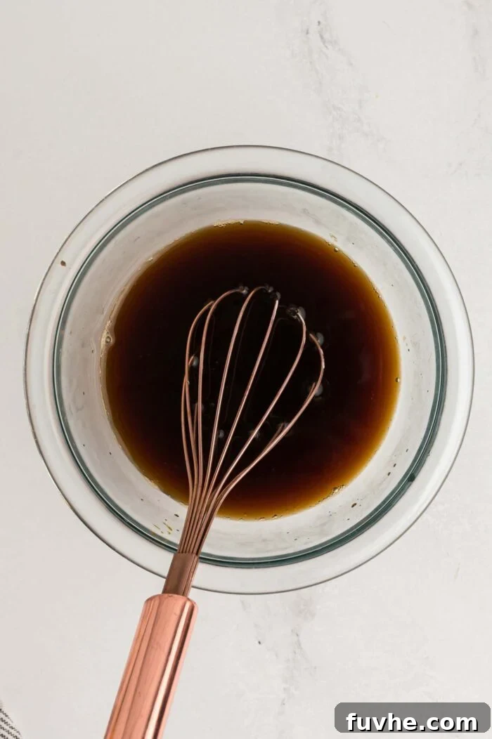 Decadent Vegan Tiramisu 15 Whisking together coffee and dark rum in a small glass bowl.
